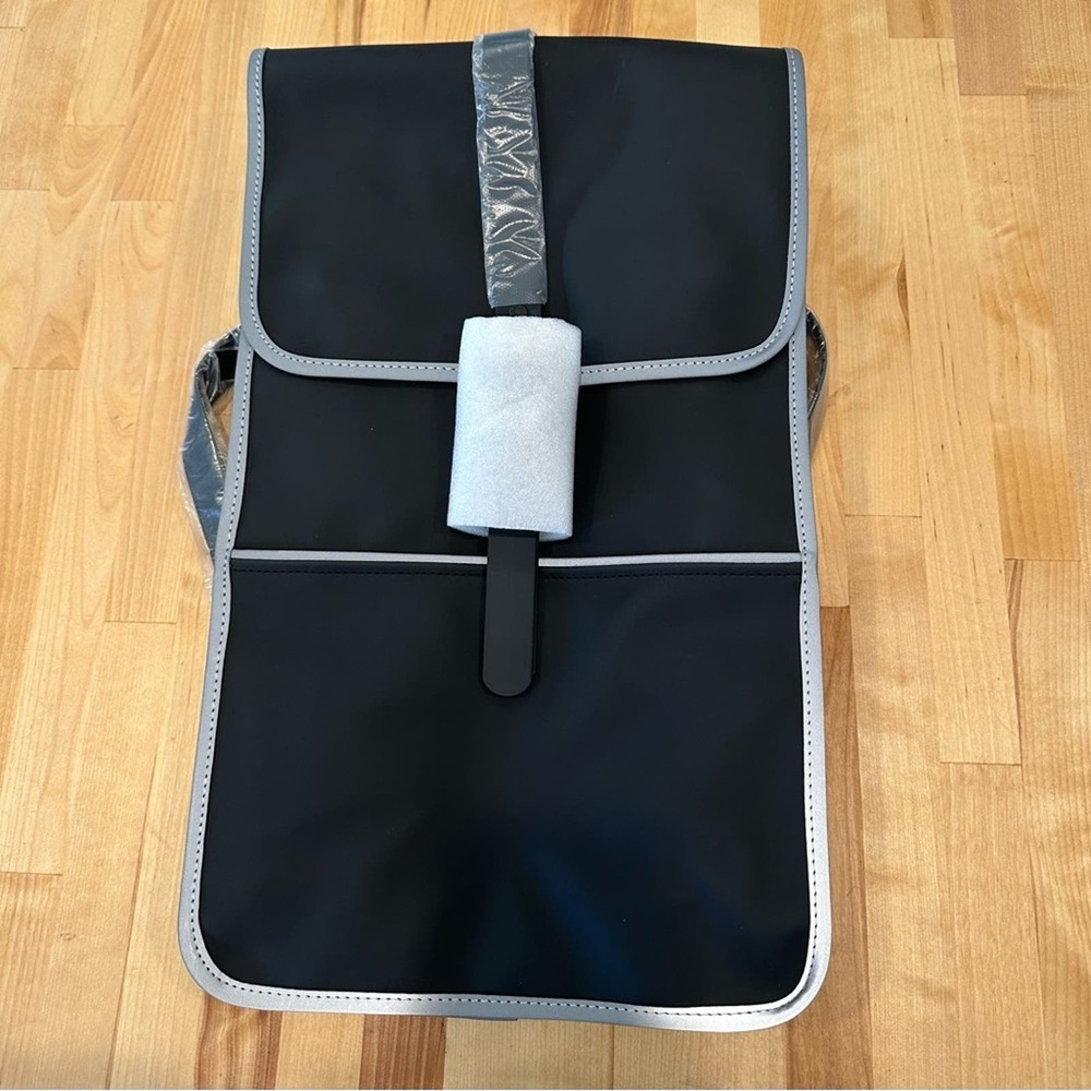 NWT Rains Full-Size Backpack in Black with reflective silver.